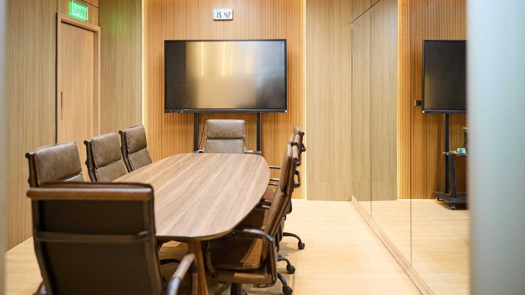 An empty conference room with an oval table and leather chairs