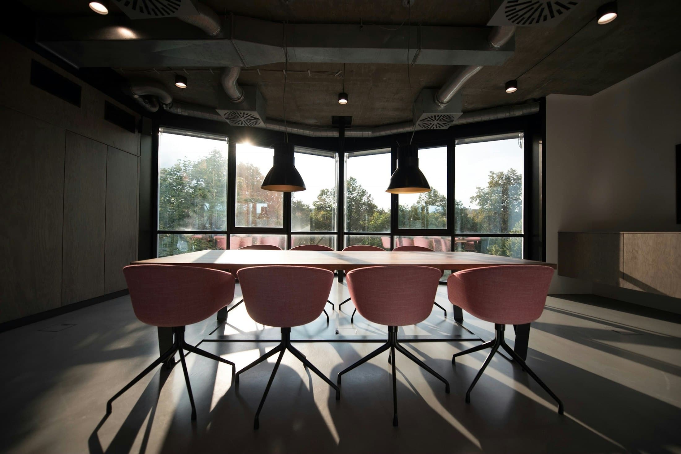 A boardroom at dusk, lit from the windows