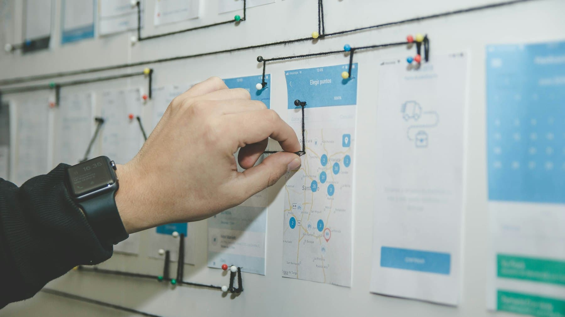 A person arranging notes across a planning board