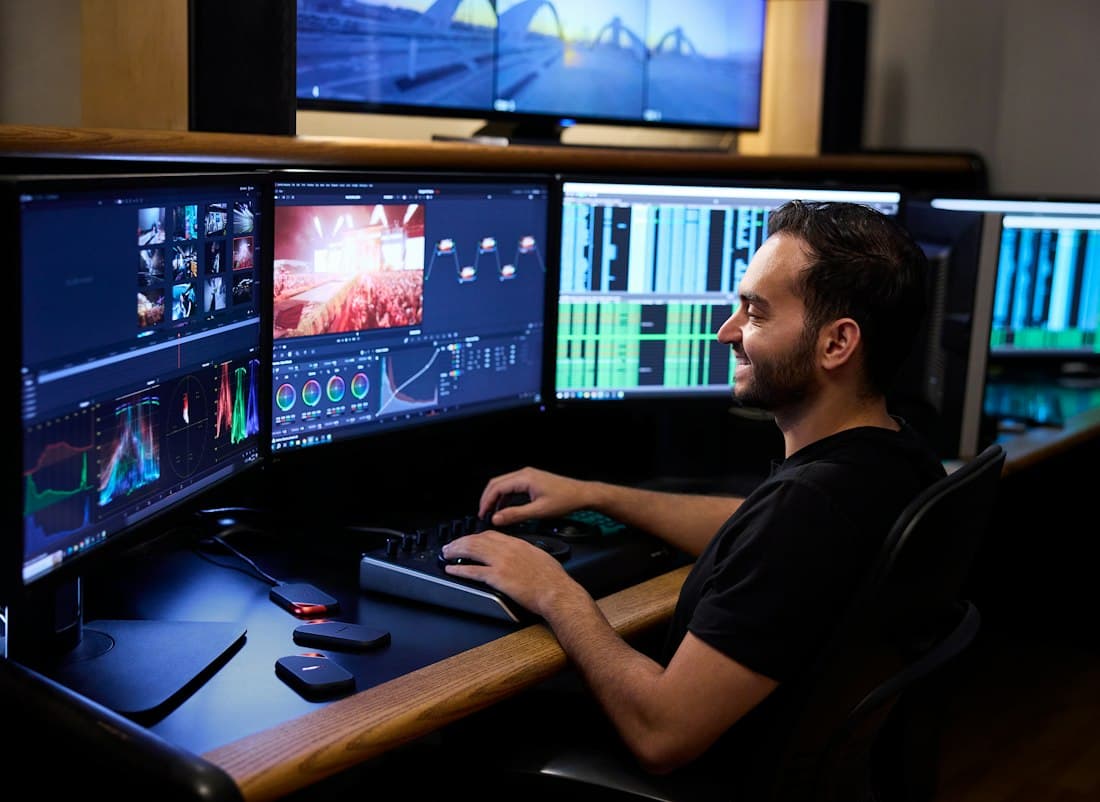 An editor grading video across multiple monitors