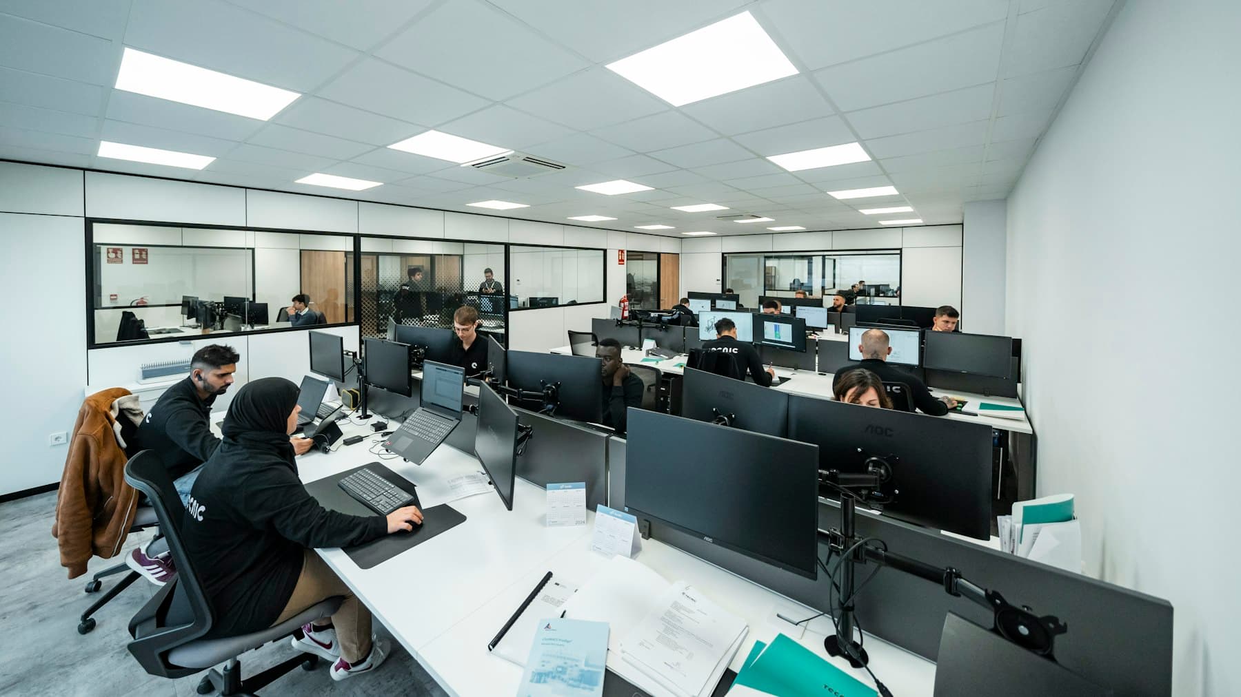 An open-plan office floor with people working at computers